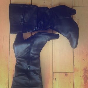 Black heeled boots with buckle .